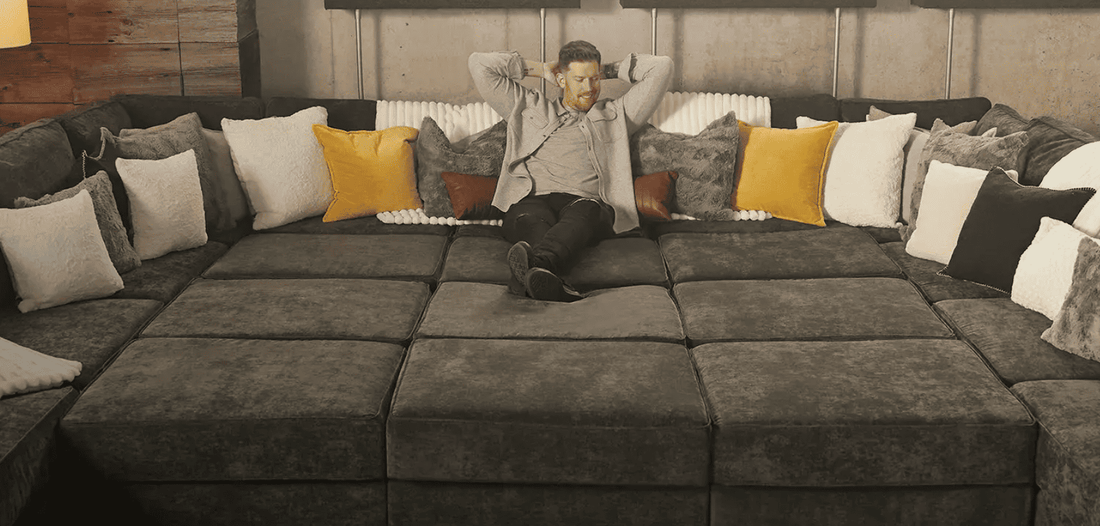 A man lost in a sea of lovesac modular sofa pieces