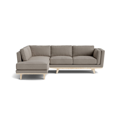 The Kirnik Bumper Sectional in Natural Latex, featuring a beige hue and L-shaped design, is set against a white background. With its left-side chaise and wooden legs, it exudes a modern, minimalist, and stylish appeal.