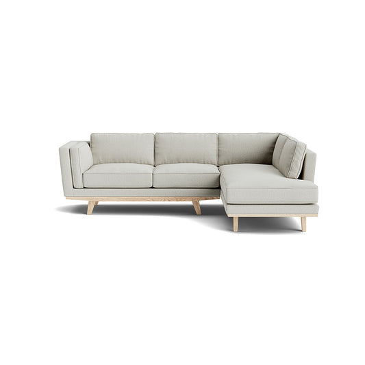 Kirnik Bumper Sectional in Natural Latex features light beige upholstery and wooden legs, showcasing clean lines and a minimalist aesthetic that is perfect for contemporary living spaces.