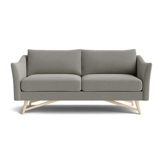 The Gio Sofa in Natural Latex is a modern grey sofa that includes two seat cushions and two back cushions. It features angled wooden legs for support and sleek, curved armrests, with textured upholstery adding an elegant touch to its minimalist design.