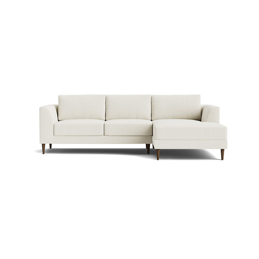 Introducing the Dekayess Chaise 98" Sectional: a minimalist beige sofa with a modern design, featuring three seat cushions and an attached chaise on the right side. It boasts clean lines and rests gracefully on four slender wooden legs against a white background.