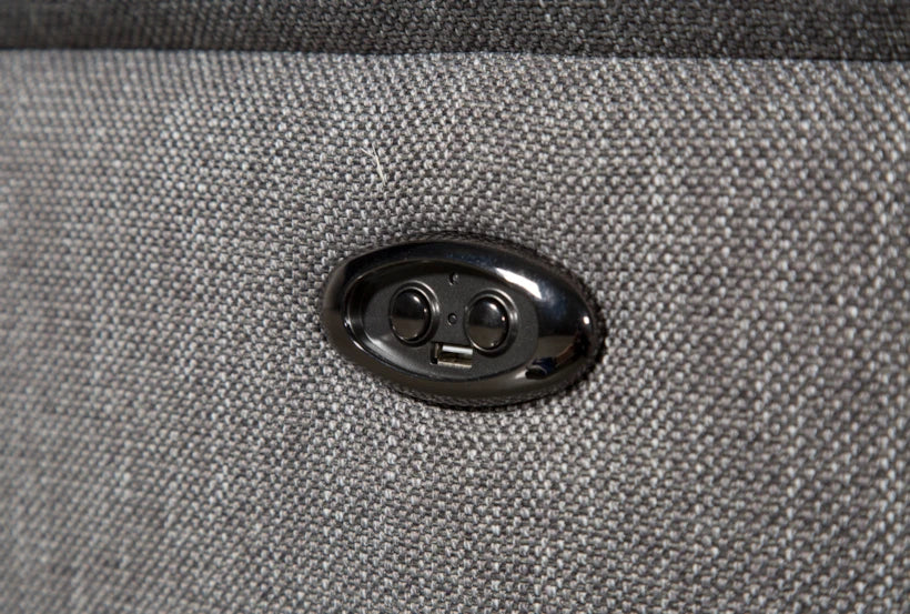 Close-up of the Talin Power Reclining Sofa with USB, featuring a black button panel on a textured gray fabric surface with two round buttons and a small USB port.