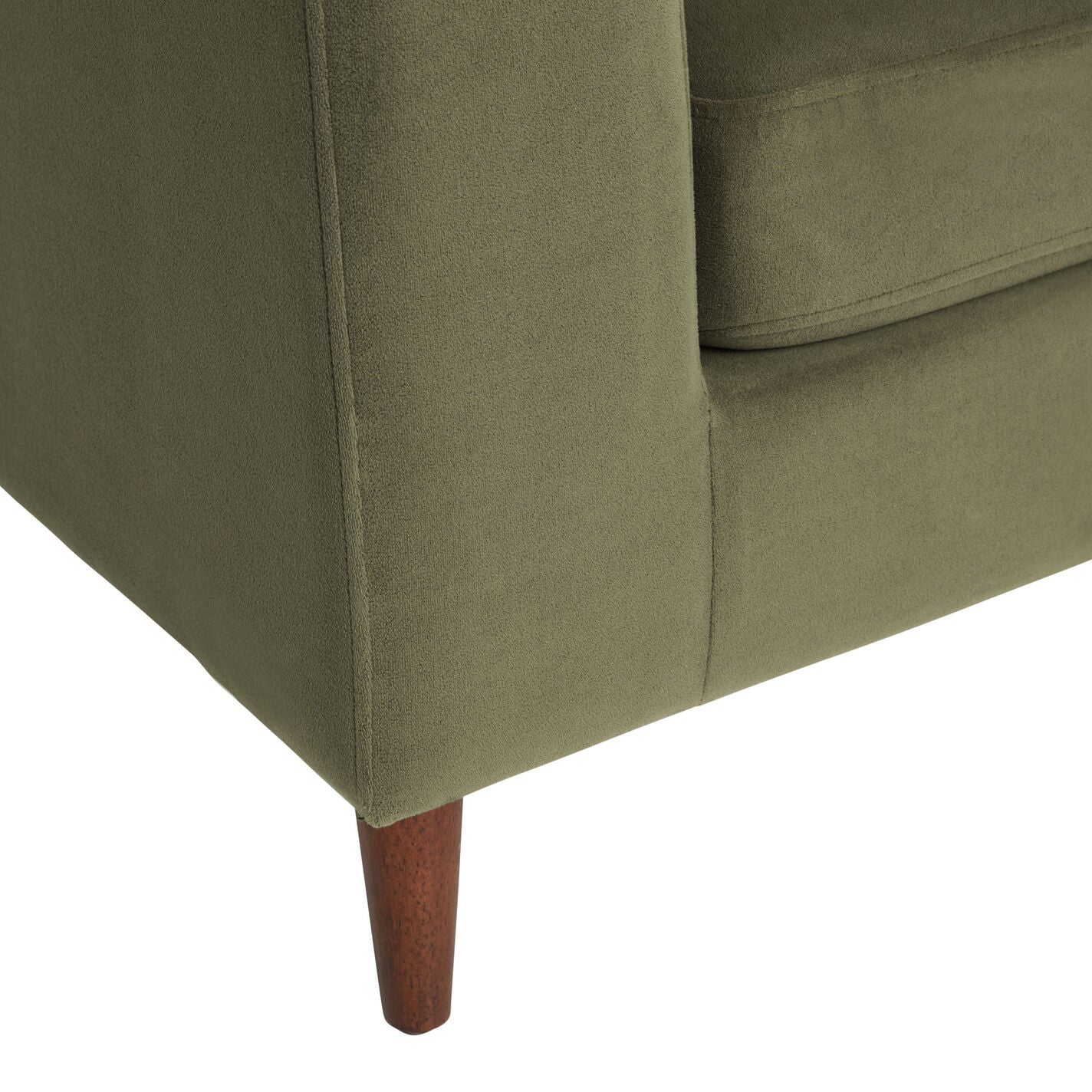 Close-up of the Camile Velvet Right-Facing Sectional Sofa, highlighting its green fabric upholstery, corner with wood-finished tapered legs, as well as the texture and structure of the armrest.