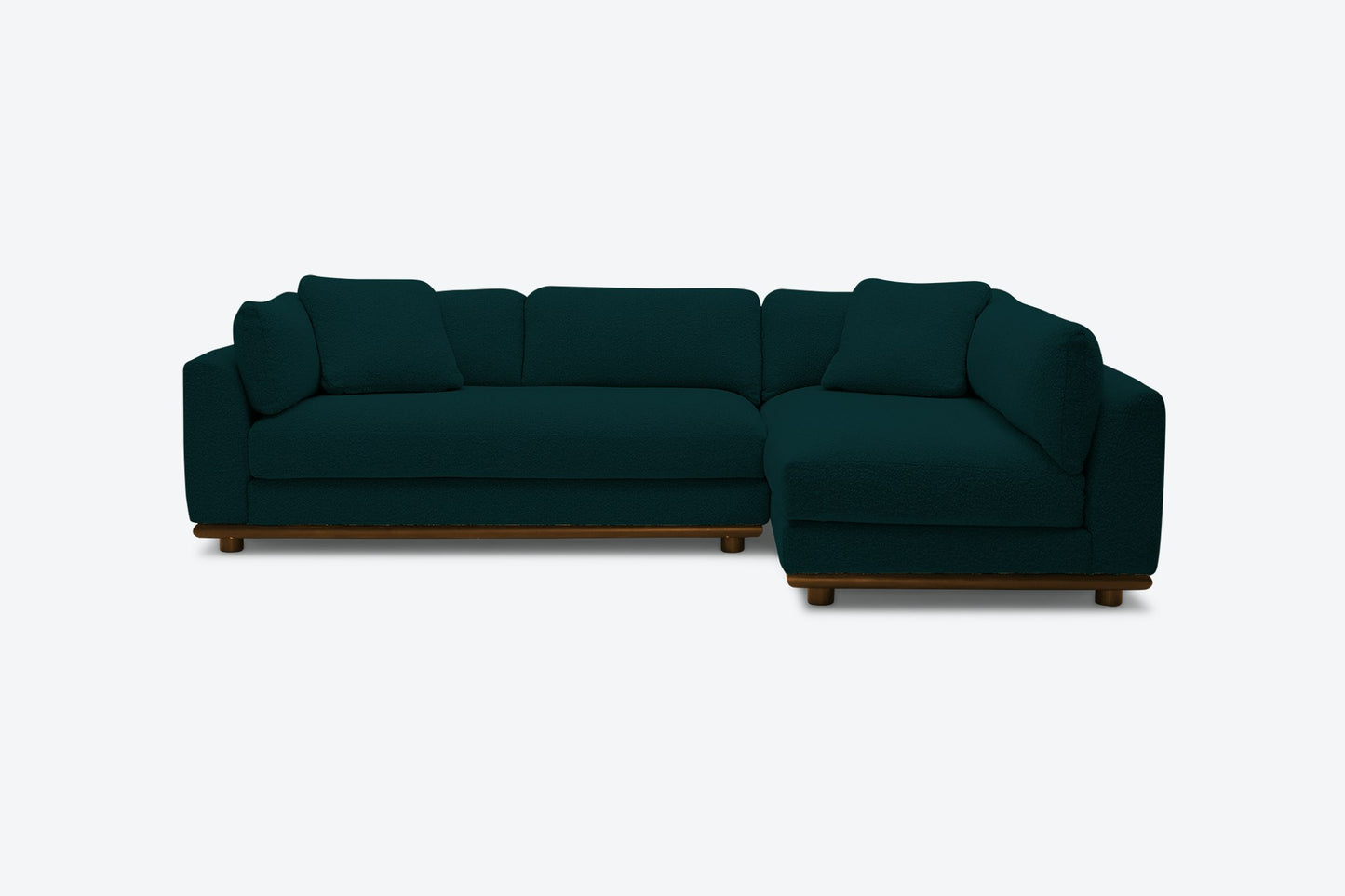 A stylish and comfortable seating option, the Miller Sectional is a dark green, L-shaped sofa with plush cushions. Its modern design features visible wooden legs and stands out beautifully against a light background.