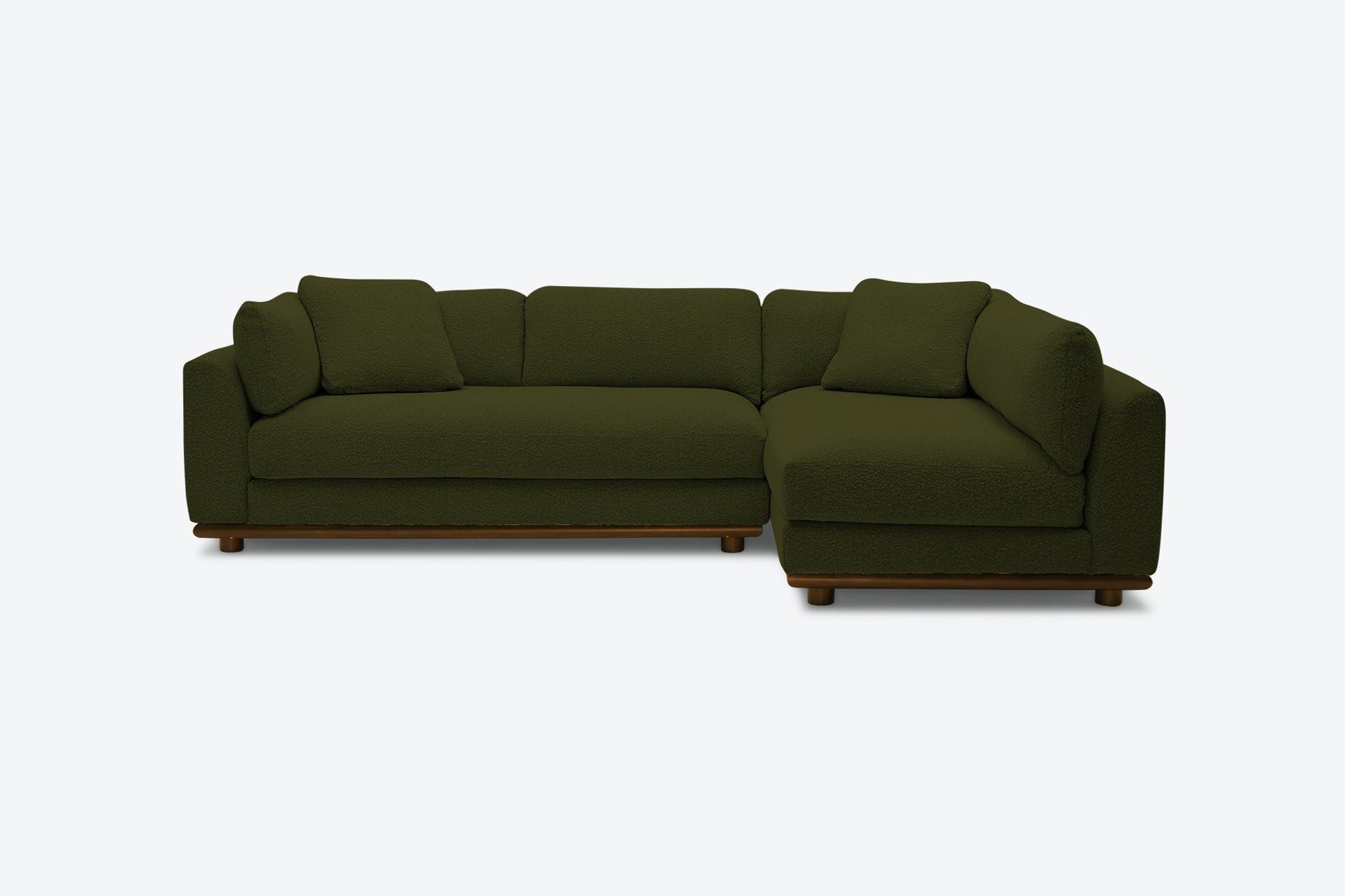 The Miller Sectional is a dark green sofa with a modern design featuring a left-facing chaise lounge, plush cushions, and wooden legs, set against a plain light background.