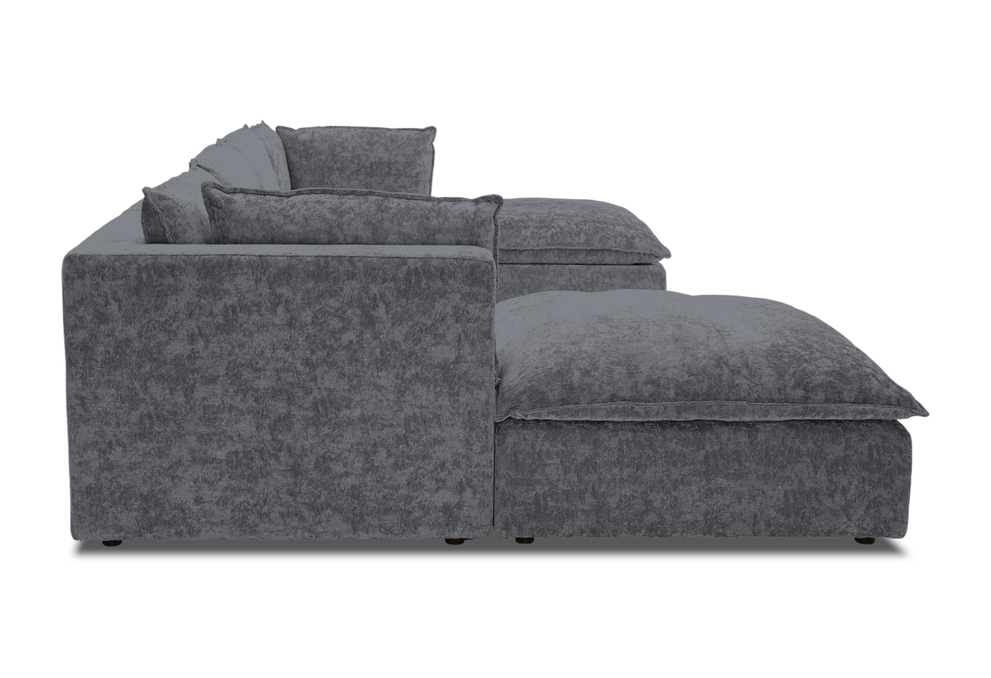 Side view of the Haine Modular Grand U-Sofa Sectional in a modern gray design, featuring plush cushions and a flat base. The textured fabric enhances its appeal, and the chaise section extends out to provide a comfortable lounging space. The background is plain white.