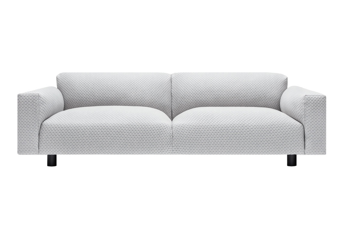 The Koti 3-seater Sofa is a modern piece with a light gray color and textured pattern. It features two seat cushions, straight arms, and four black cylindrical legs, all set against a plain white background.