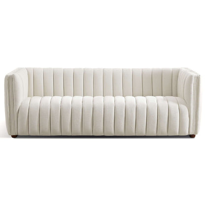 The April Mid-Century Modern Luxury Tight Back Boucle Couch features a sleek white design with vertical channel tufting, a boxy shape, low back and arms, and small round wooden legs. Its upholstery is soft and plush.