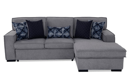 The Playscape Gray 94'' 2 Piece Pop-Up Sleeper Chaise Sectional features an attached chaise lounge and comes with three dark pillows adorned with textured patterns, as well as three additional pillows showcasing a blue diamond design. It boasts a modern, minimalist style.