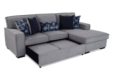 The Playscape Gray 94'' 2 Piece Pop-Up Sleeper Chaise Sectional is a contemporary sofa that includes an extended chaise and pull-out storage. It comes with six cushions, showcasing a combination of solid black and black-and-blue geometric pattern designs.