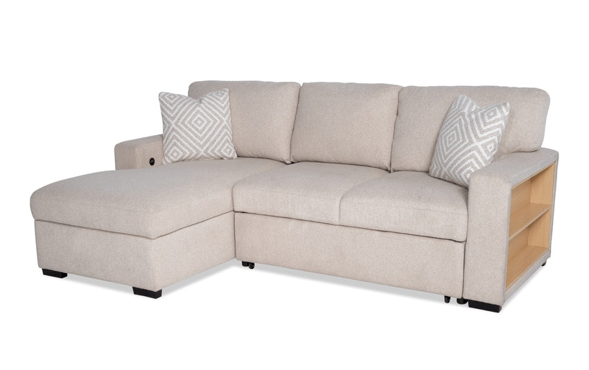 A beige Playday sectional sofa with a left arm facing chaise, featuring two patterned pillows and open wooden shelves on the right armrest. This 93'' two-piece sectional can also transform into a pop-up sleeper and includes USB and USB-C ports for added convenience.