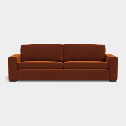 The Barton Sofa features a minimalist and stylish design with its modern brown upholstery, clean lines, and square armrests set against a light gray background. It includes two seat cushions and two back cushions.