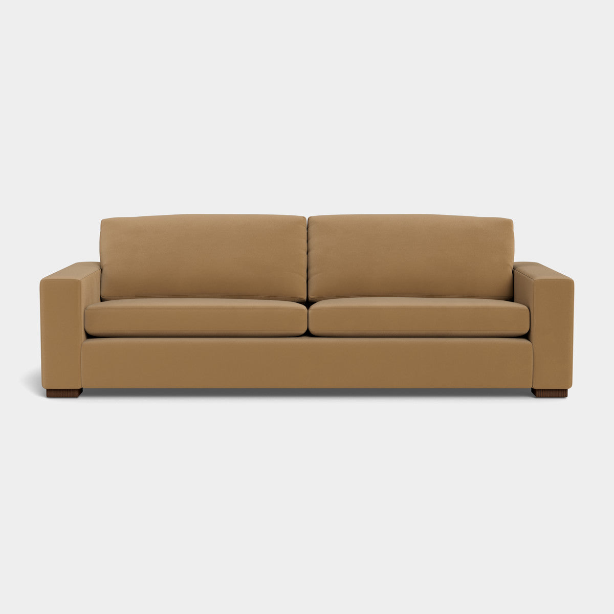 The Barton Sofa, a modern piece with a boxy design, is made from brown leather and showcases two seat cushions and two back cushions made from the same material. It features wide armrests and dark wooden feet, all displayed against a plain white background.