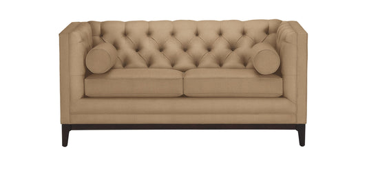 The Anderson Loveseat is a beige tufted design featuring a high back and sides. It comes with two seat cushions, two cylindrical accent pillows, and is supported by dark wooden legs.