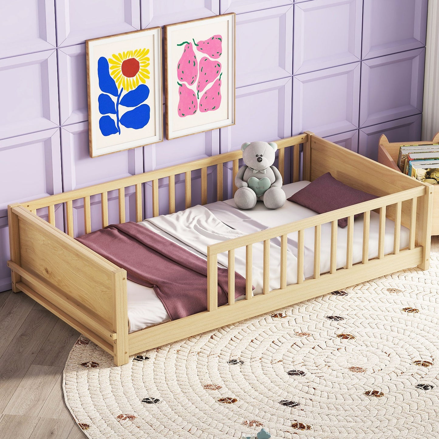 A Floor Platform Bed with Built-In Book Storage, a white mattress, mauve blanket, and stuffed bear sits on a round decorative rug. The wall is light purple with geometric patterns and has two colorful art pieces hanging above the bed.