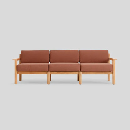 The Haven Sofa is a three-seater with a wooden frame and brown cushions, displayed against a plain light gray background. Its design is minimalist and contemporary.