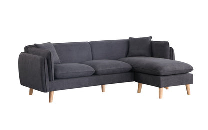 The Brayden Fabric Sectional Sofa Chaise is a modern dark gray piece with wooden legs, clean lines, and plush cushions. Its right section forms a chaise lounge, offering a comfortable relaxation space.