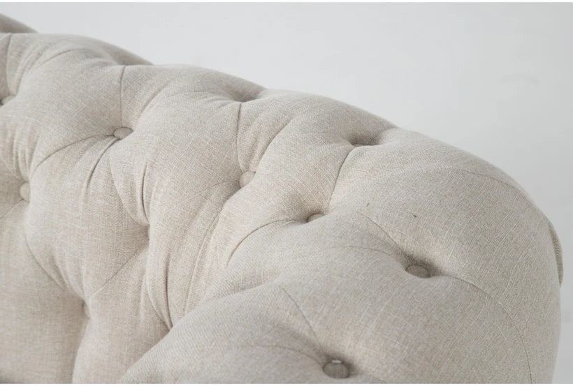 Close-up of the tufted fabric surface of the Elis Wheat 73 Inch Chesterfield Loveseat, featuring button detailing and a soft, textured pattern.