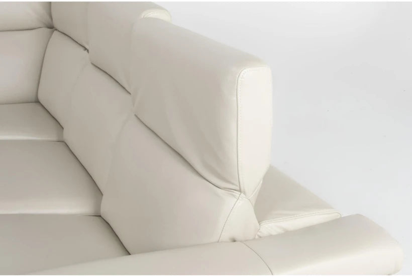 Close-up view of the Bennett Leather 2 Piece Reclining Sectional with Left Arm Facing Chaise in light beige, featuring plush cushions and sturdy armrests that highlight its texture and design.