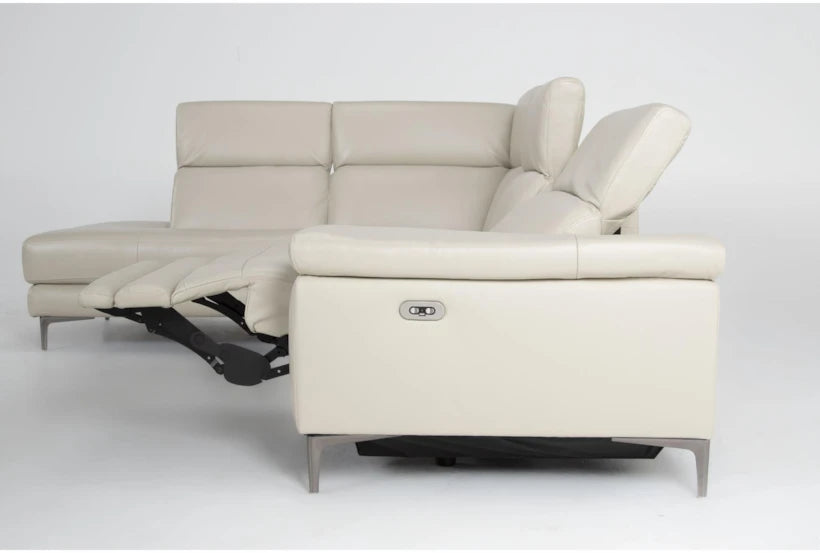 The Bennett Leather 2 Piece Reclining Sectional with Left Arm Facing Chaise features a beige leather finish and metal legs set against a white background. The left arm facing chaise extends into a recliner, revealing the mechanism. Its modern and sleek design highlights both comfort and style.