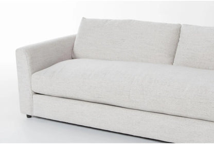 The Thea Down 101 Inch Beige Chenille Sofa is depicted with a minimalist design, showcasing a plush, light gray color. It includes a single seat cushion and two large back cushions against a plain white background, featuring a low-profile armrest on one side.