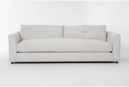 The Thea Down 101 Inch Beige Chenille Sofa, featuring a minimal design, is set against a plain white background. This modern piece includes two large back cushions and low, blocky armrests for a contemporary look.