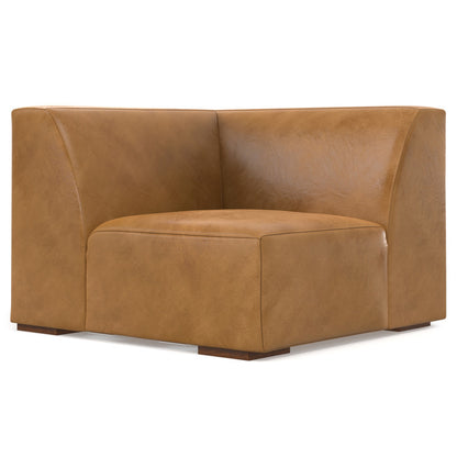 A brown leather corner chair with a smooth texture and minimalist design. It has a high backrest and is supported by small, low-profile legs. The chair features a boxy yet comfortable appearance, making it a stylish addition to modern interiors.