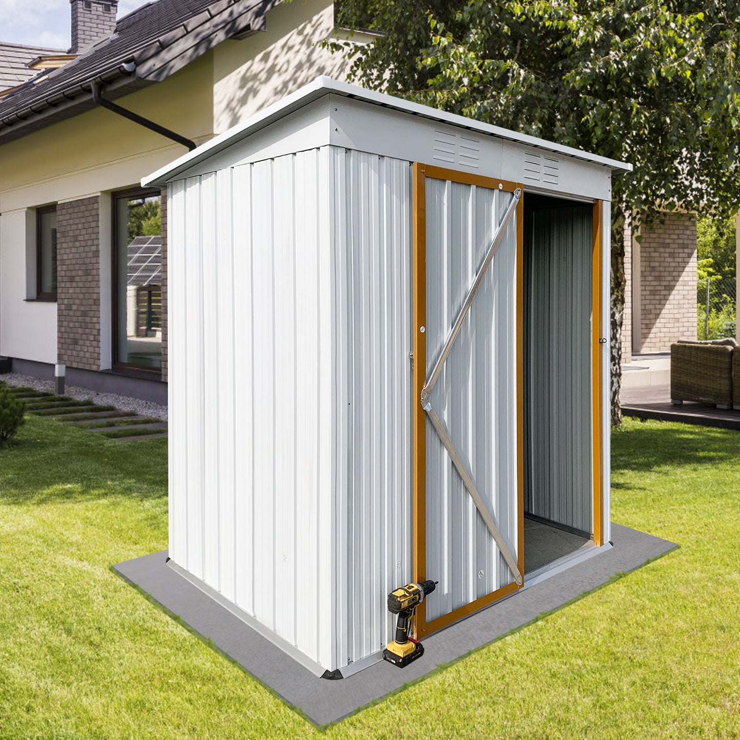 A Garden Sheds 5FtX4Ft Outdoor Storage Shed with an open door stands on a grassy lawn, with a power drill on the ground nearby. The shed is adjacent to a modern house partially visible among trees.