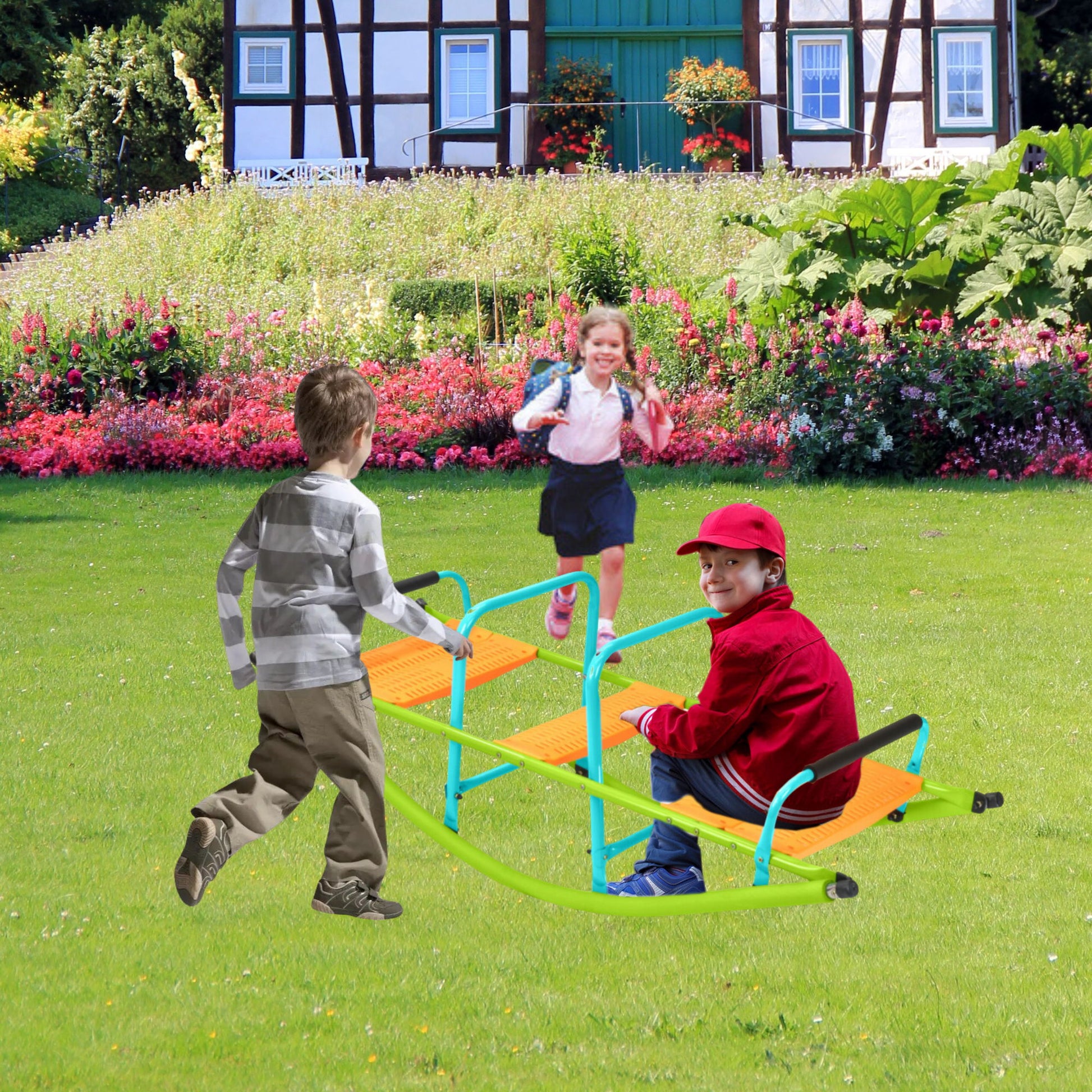 Three kids enjoy the Xss008 High Quality Kids Seesaw in a garden. A boy in a striped shirt stands, a girl in a pink jacket approaches, and a boy in a red cap sits. Behind them is a house with vibrant flowers.