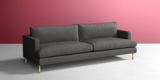 The Bowen 91" Sofa, featuring a modern design with two seat cushions and sleek armrests, stands on short metallic legs. It is set against a two-tone background with pink and white walls.