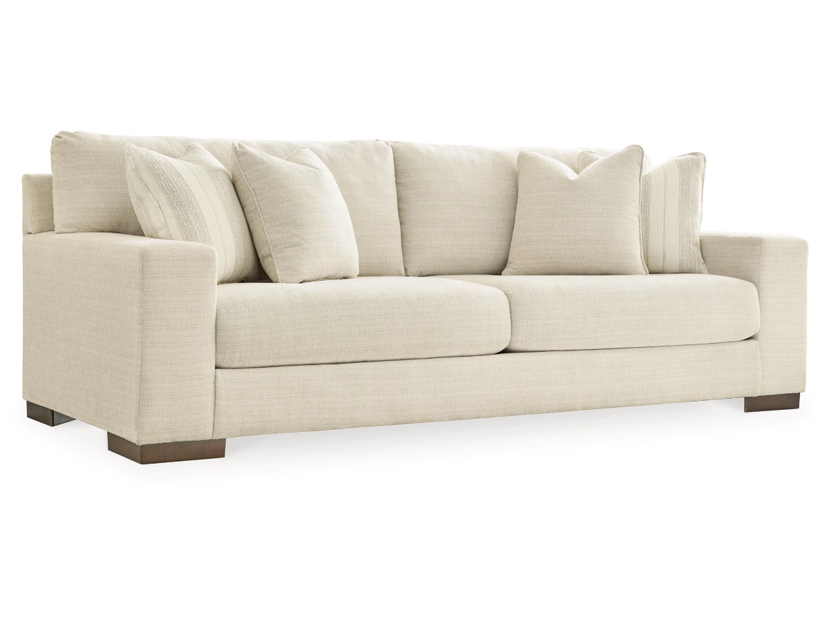 The Maggie Sofa is a beige fabric piece with two large seat cushions and multiple back cushions. It features dark wooden legs, boasts a modern design, and includes four coordinating throw pillows.