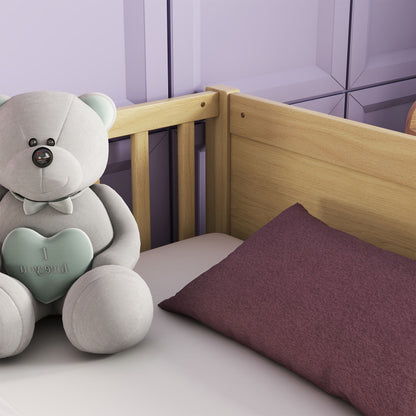 A gray teddy bear with a light blue heart reading "I love you" sits on a white bed next to a purple pillow. The bed, featuring the Floor Platform Bed with Built-In Book Storage Rack, has a light wooden headboard and is placed against a purple paneled wall.