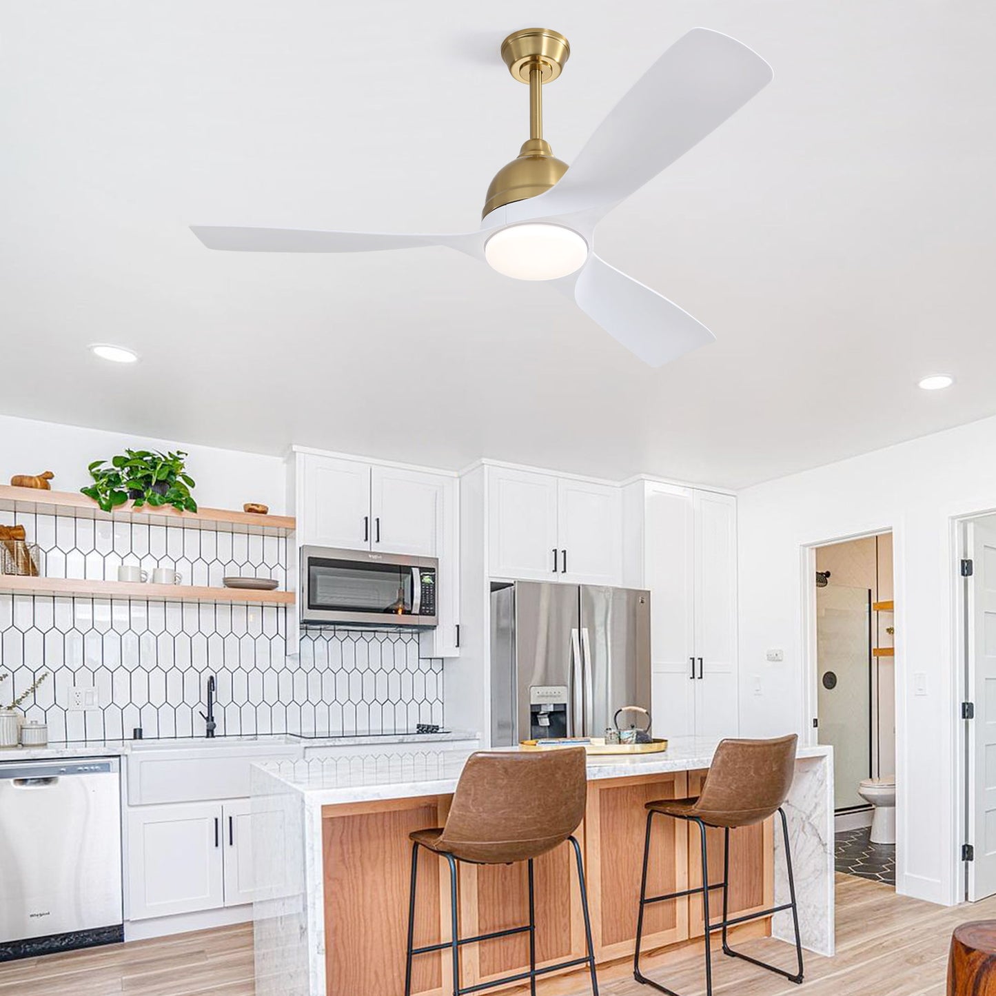 Modern kitchen with white cabinets, hexagonal backsplash tiles, and stainless steel appliances. Wooden island with two brown leather stools. A Modern Ceiling Fan 6 Speed Remote Control with light hangs above. Open doorway leads to another room.