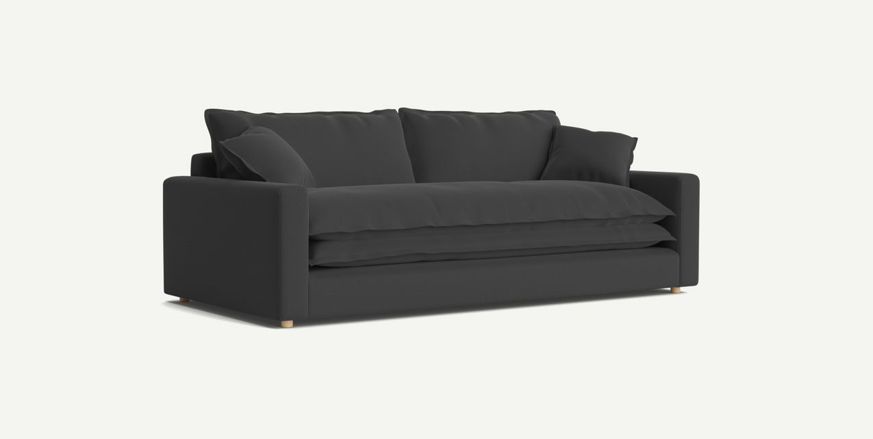 The Meriwether Sofa features a minimalist design with plush cushions and a sleek modern aesthetic, displayed against a plain white background. Its contemporary look is enhanced by black upholstery and wooden legs.