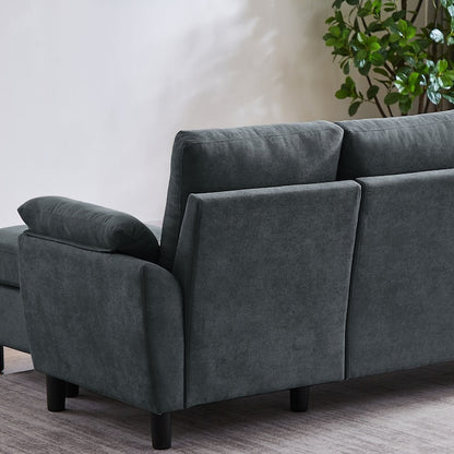 The Jarenie Casual Dark Grey Linen Sectional is artfully placed on a light-colored rug. Situated near a wall and accompanied by a potted plant to the right, it enhances the cozy ambiance of the room.