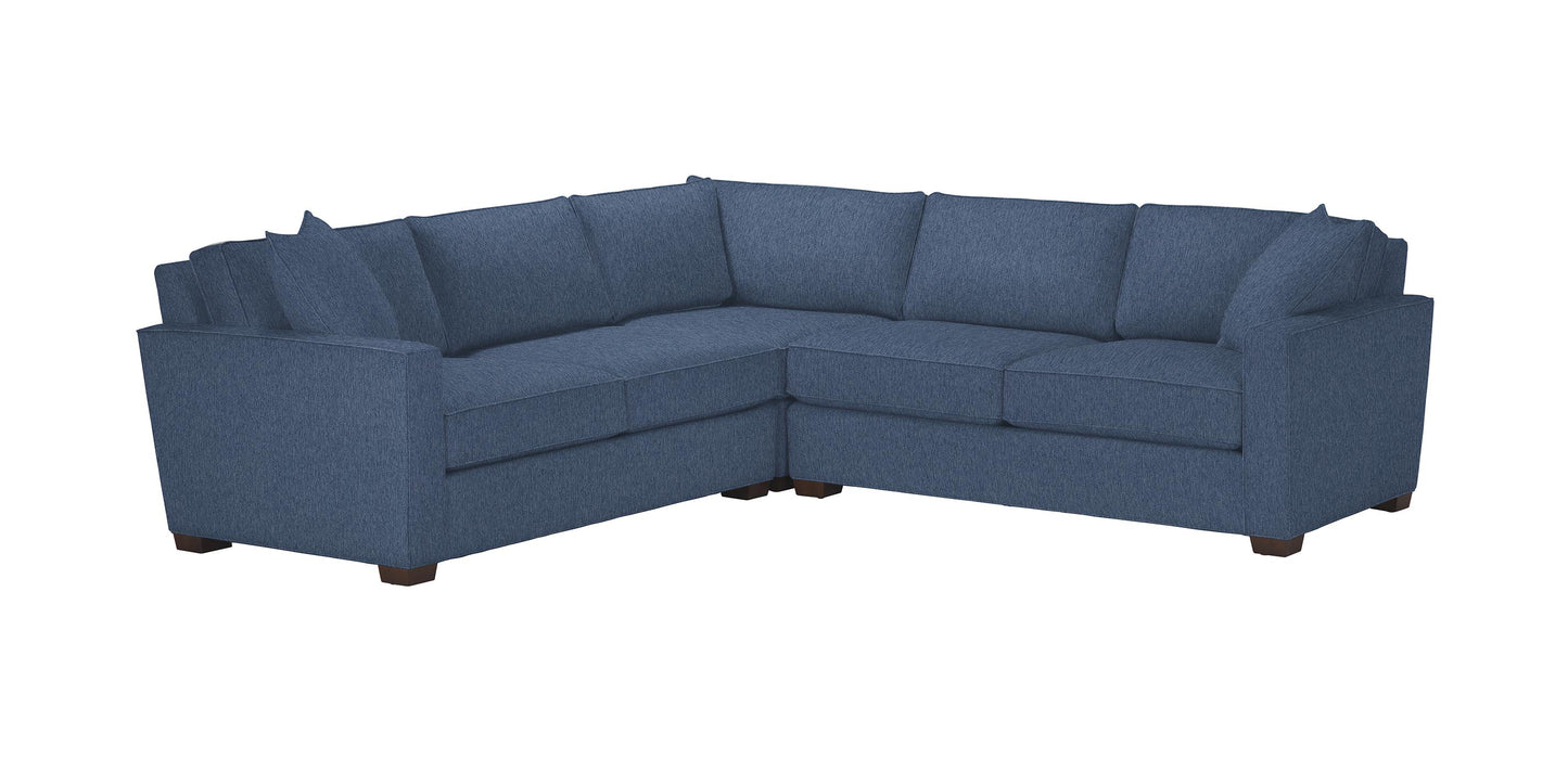 The Spencer Track-Arm 3-Piece Sectional, Quick Ship is a blue L-shaped sofa with clean, modern lines and plush cushions. It includes three sections, featuring a corner piece, to offer ample seating space. The design is complemented by simple wooden legs and textured fabric.