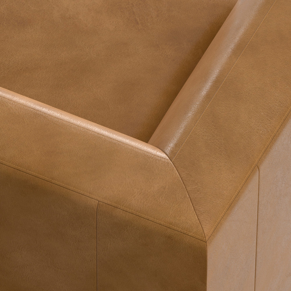 Close-up view of the corner of a light brown leather couch showing the smooth texture and stitching details.