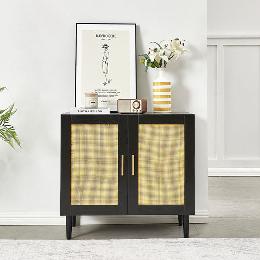 The Side Panel Buffet Cabinet, featuring natural rattan doors and gold handles, is topped with a striped vase of white flowers, a small radio, and a fashion poster. A plaque reads "TRUTH LIES LOW." A potted plant sits on the floor beside it.