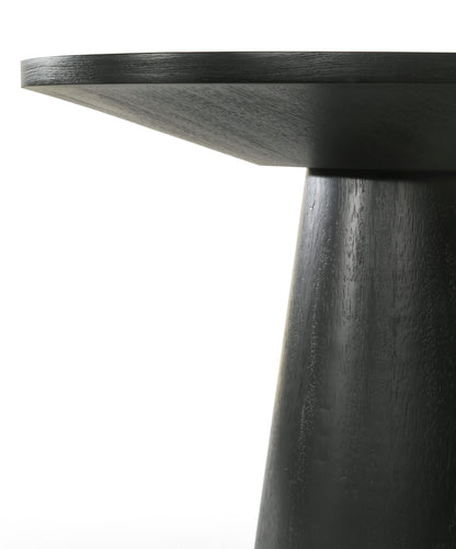 Close-up of the Jasper Round Table, featuring a sleek, dark wooden circular top and a thick conical base. The smooth, polished surface showcases visible grain patterns against a white background, accentuating its minimalist design.