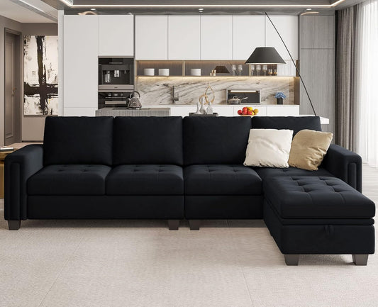 A modern living room features the Belffin Reversible Sectional Convertible Storage sofa, adorned with white and beige cushions. The backdrop showcases a contemporary kitchen with sleek white cabinets, a marble backsplash, and a countertop decorated with fruit and various decorative items.