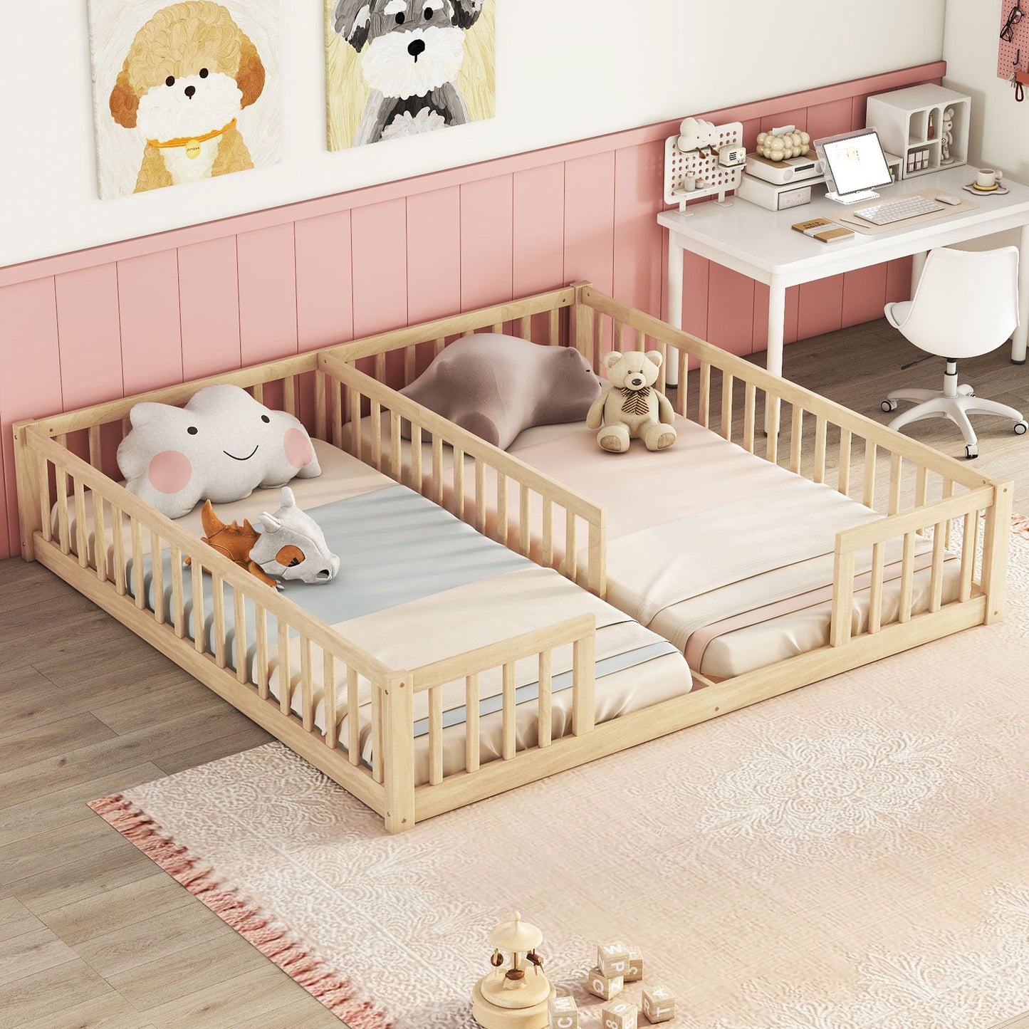 A children's room with a Double Floor Bed With Fence, Guardrails, Without Door side by side and plush toys. The walls are pink and white with animal-themed art. A small desk with a chair and toys sits in one corner on a light-colored patterned rug.