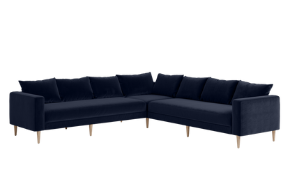 The Essential Corner Sectional (7 Seat) features a dark blue velvet upholstery and wooden legs in an L-shaped design.