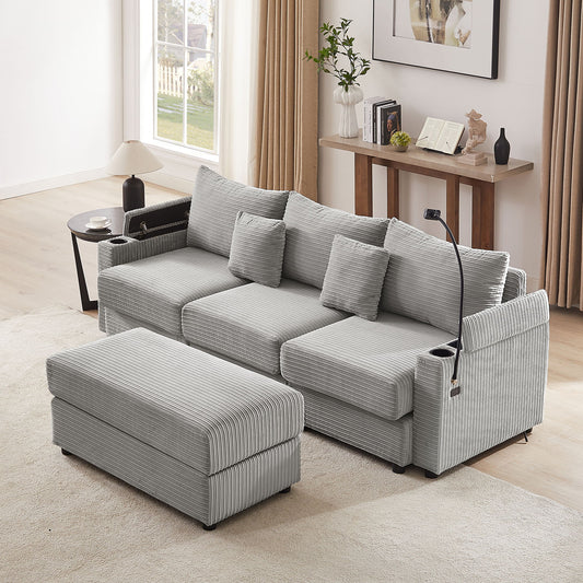 A light gray, textured Modern Style Loveseat Sectional Sofa with storage, includes a matching movable ottoman, two USB ports, cup and phone holders. It sits near a wooden console table with decor in front of a large window with curtains. A floor lamp is attached to one armrest.