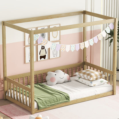 A Canopy Frame Floor Bed With Fence and guardrails, featuring a pastel triangular banner, green blanket, plaid pillow, and an elephant cushion. The room is painted white and peach with bear-themed wall art.