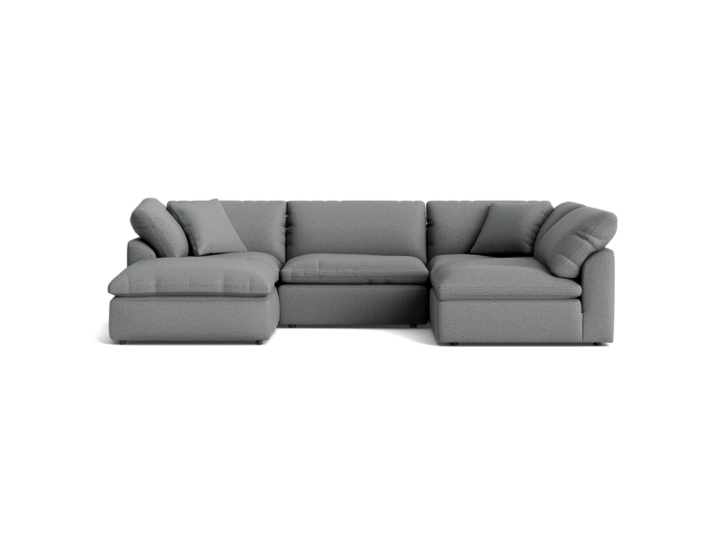 A stylish Bryant U-Sofa Bumper Sectional in gray, featuring plush cushions and a left-hand chaise, set against a solid black background.