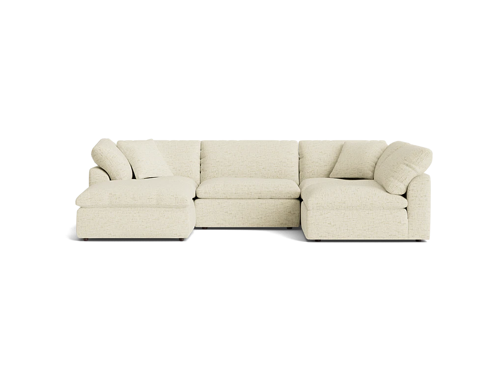 The Bryant U-Sofa Bumper Sectional, a beige L-shaped sofa with cushioned seats and backrests, is placed against a plain black background. This inviting and comfortable design is ideal for a modern living room.