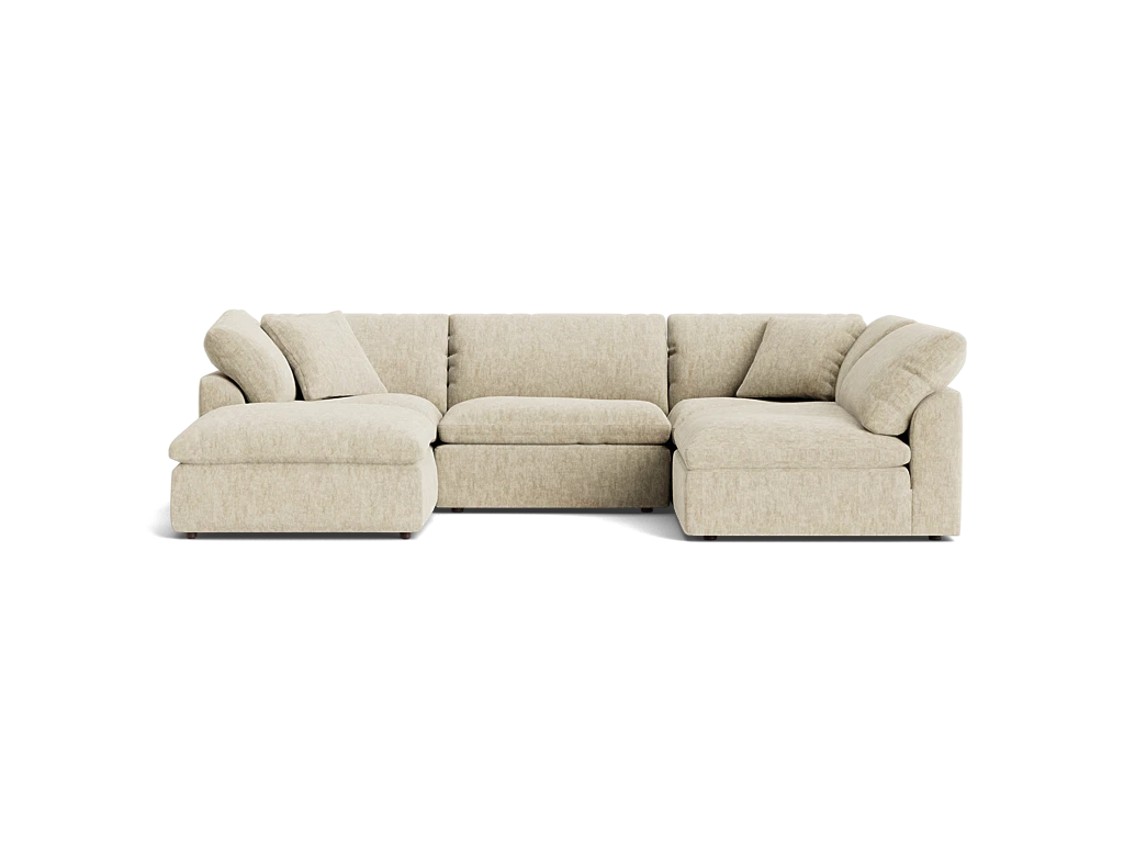 A Bryant U-Sofa Bumper Sectional in beige, featuring an L-shaped design with a chaise on the left side, plush cushions, and a low-profile style, set against a plain black background.