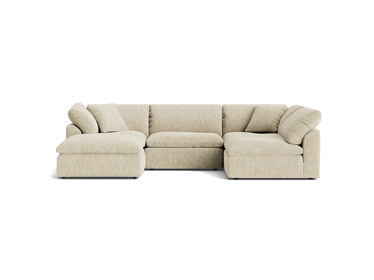 A Bryant U-Sofa Bumper Sectional in beige, featuring an L-shaped design with a chaise on the left side, plush cushions, and a low-profile style, set against a plain black background.