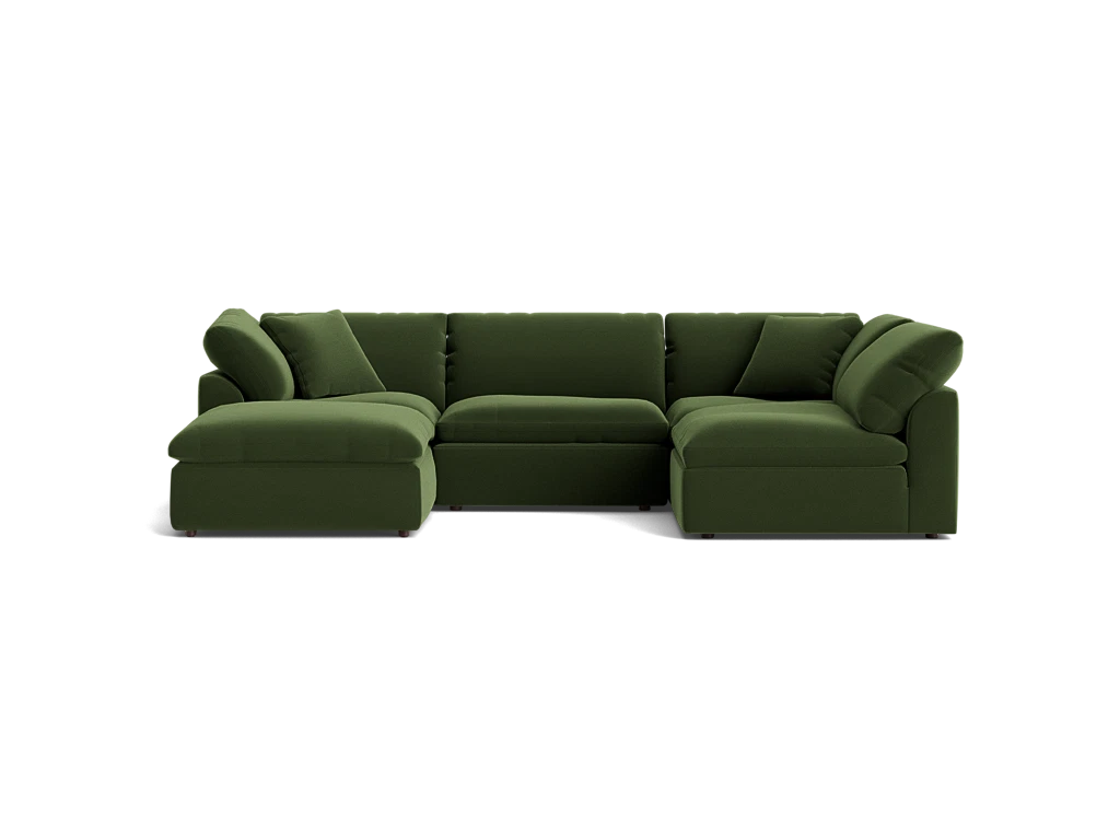 The Bryant U-Sofa Bumper Sectional is a spacious, dark green sectional sofa featuring a left-side chaise. Its plush and minimalist design is complemented by multiple cushions, all set against a simple black background.