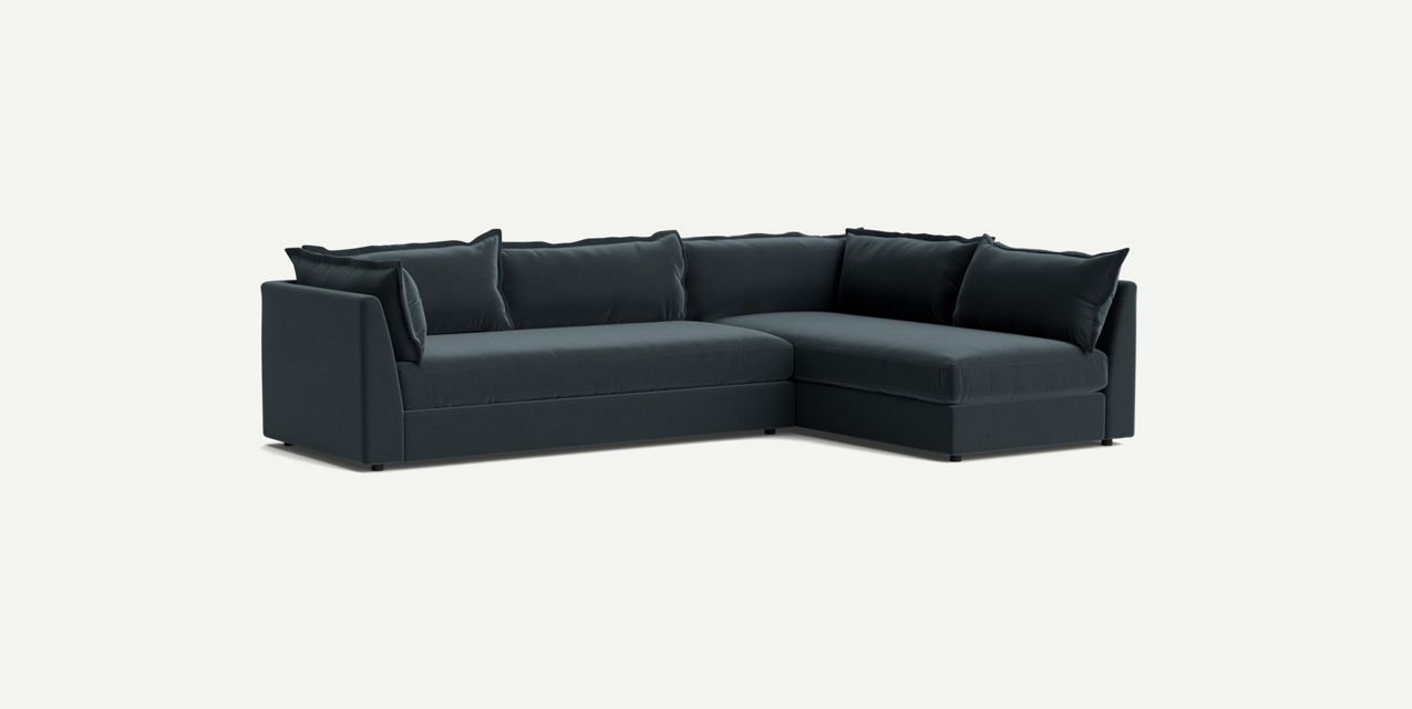 The Denver Two Piece Velvet L-Shaped 119" Sectional is a dark green sofa featuring plush cushions that stand out against a light background. It boasts a modern, minimalist design with clean lines and deep seating.